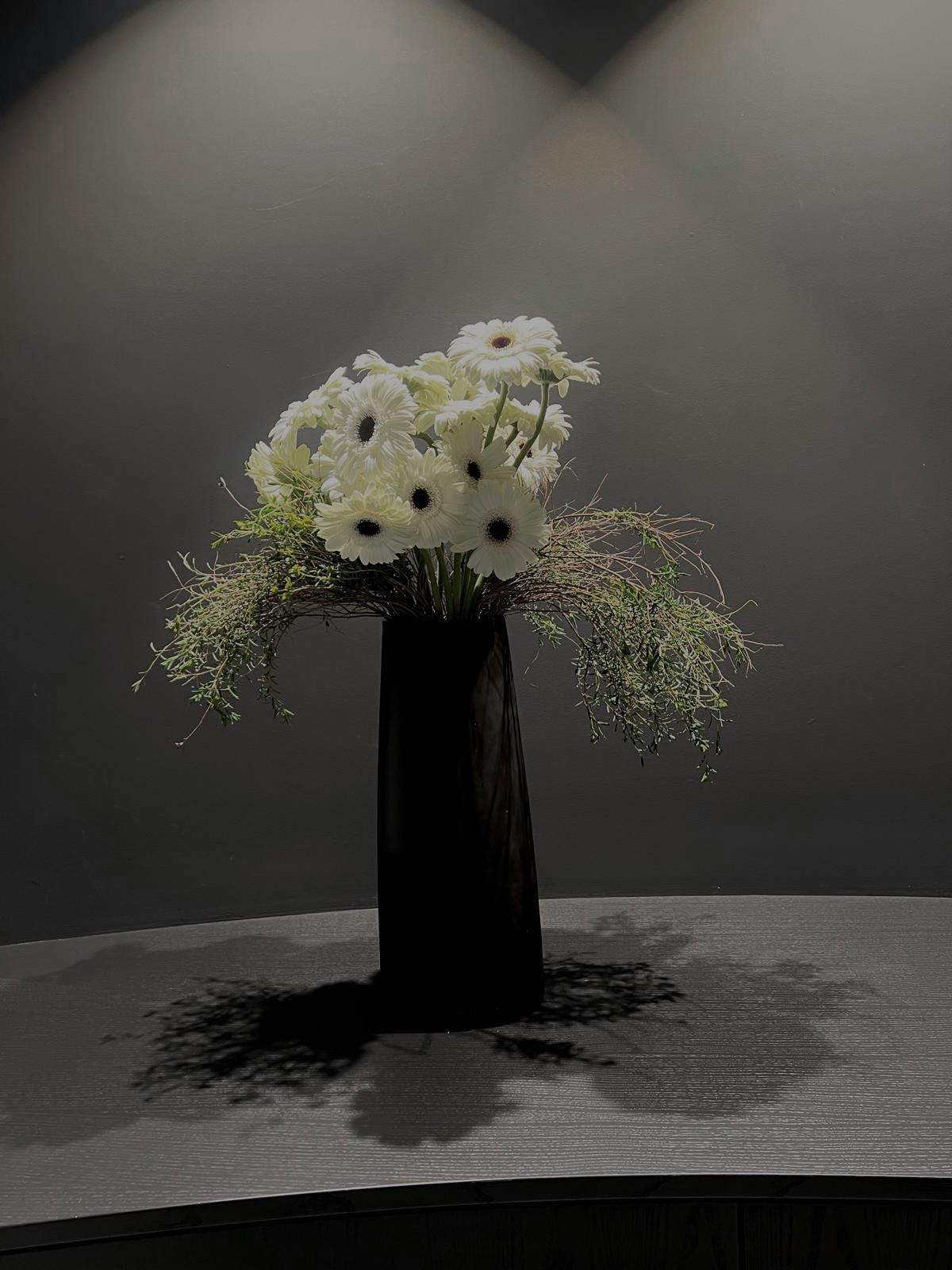 Seasonal botanicals composed in a dark vessel
